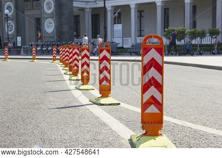 Orange Road Dividers. Curved Line Of Dividing Posts On The Double Road Marking Line.