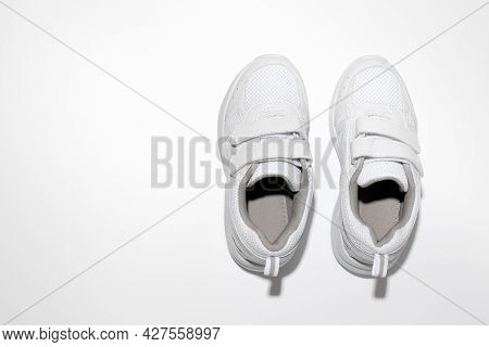 Mock Up White Girl Sneakers With Velcro Fasteners With Hard Light Isolated On White Background
