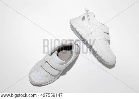 Top View White Unisex Running Shoes With Velcro Fasteners For Easy Footwear With Hard Shadows Isolat