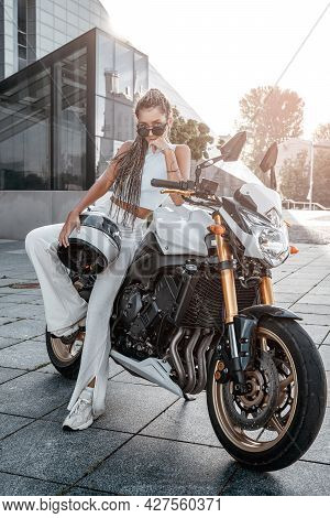 Woman With Motorcycle Helmet Leaning Motorbike On Sidewalk