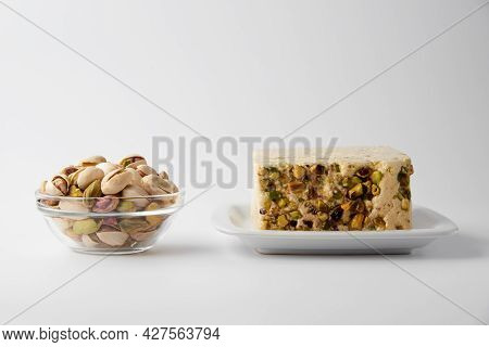 Organic Halva With Pistachios On A White Plate Isolated On White. Traditional Middle Eastern Sweets.