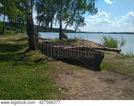 An Old Wooden Boat Is Stored On The Shore Next To The Birch Trees. Voronezh. Russia. July 2019
