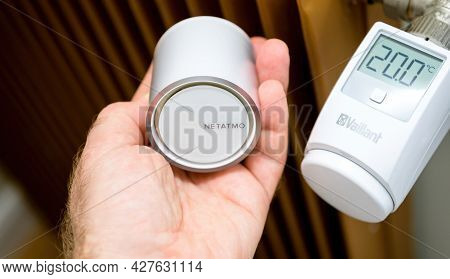 Paris, France - Apr 21, 2021: Pov Male Hand Comparing Netatmo Radiator Thermostatic Head Next To The