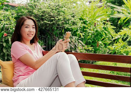 Portrait Asian Woman Enjoys A Kalimba, Or Thumb Piano, An African Traditional Instrument In Her Gard