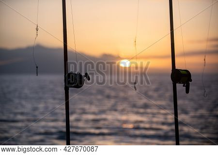 Fishing Rods Over A Beautiful Seascape. Sanset On Sea.
