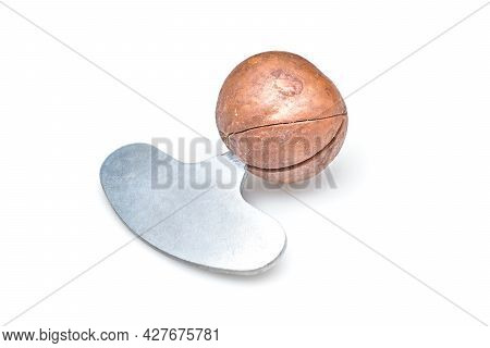 Macadamia Nuts Isolated On White Background. Next Comes The Opening Tool. Selective Focus