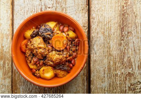 Jewish Dish Chelnt With Meat On A Wooden Table In A Plate. Copy Space Horizontal Photo