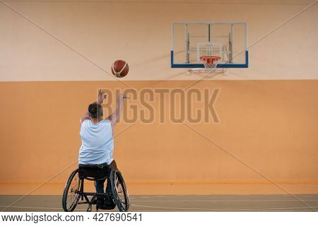 a photo of a war veteran playing basketball with a team in a modern sports arena. The concept of sport for people with disabilities