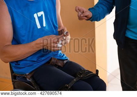 a handicapped basketball player prepares for a match while sitting in a wheelchair.preparations for a professional basketball match. the concept of disability sport
