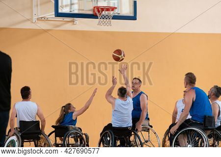 disabled war veterans in action while playing basketball on a basketball court with professional sports equipment for the disabled