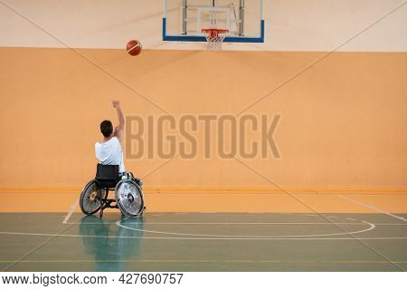 a photo of a war veteran playing basketball with a team in a modern sports arena. The concept of sport for people with disabilities