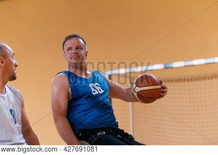 a photo of a war veteran playing basketball with a team in a modern sports arena. The concept of sport for people with disabilities