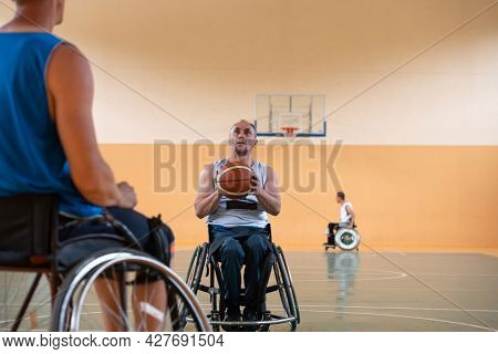 handicapped war veterans in wheelchairs with professional equipment play basketball match in the hall.the concept of sports with disabilities