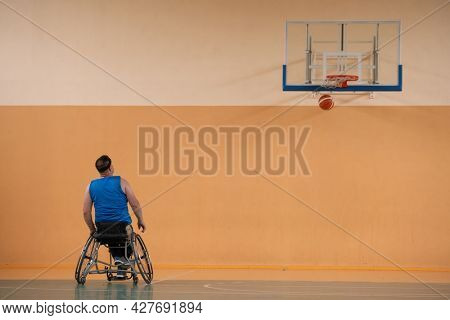 a photo of a war veteran playing basketball with a team in a modern sports arena. The concept of sport for people with disabilities