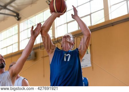 handicapped war veterans in wheelchairs with professional equipment play basketball match in the hall.the concept of sports with disabilities
