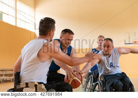 disabled war veterans in action while playing basketball on a basketball court with professional sports equipment for the disabled