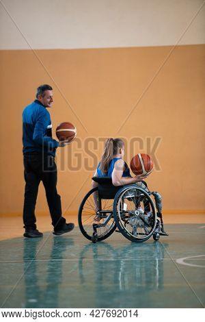 a sports basketball coach explains to a disabled woman in a wheelchair which position to play during a game