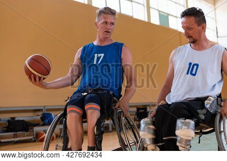 handicapped war veterans in wheelchairs with professional equipment play basketball match in the hall.the concept of sports with disabilities