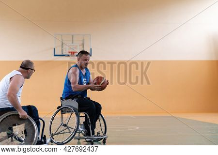 disabled war veterans in action while playing basketball on a basketball court with professional sports equipment for the disabled