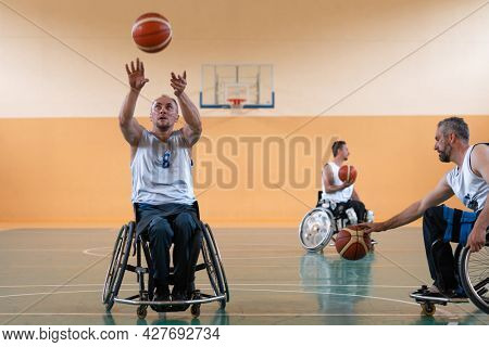 a photo of a war veteran playing basketball with a team in a modern sports arena. The concept of sport for people with disabilities