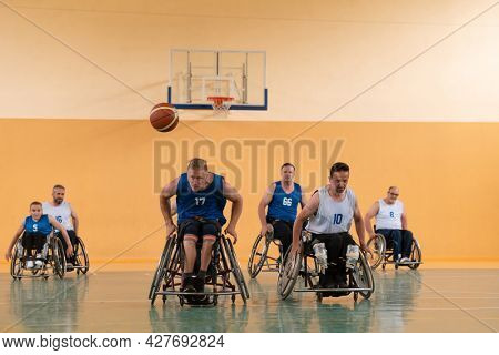disabled war veterans in action while playing basketball on a basketball court with professional sports equipment for the disabled