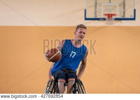 disabled war veterans in action while playing basketball on a basketball court with professional sports equipment for the disabled