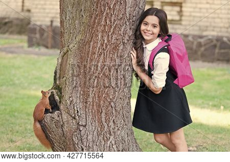 Happy Small Kid In Uniform With School Backpack Resarch Squirrel Climbing Tree In Park, Zoology.