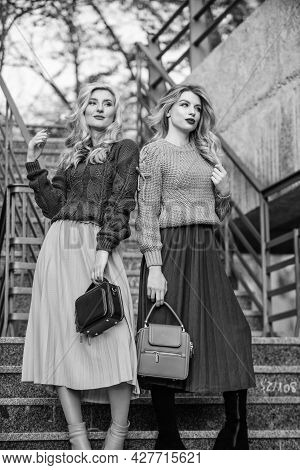 Sweater Skirt Trend. Matching Outfits. Women Sisters Outdoors Stairs Background. Matching Colors. Pe