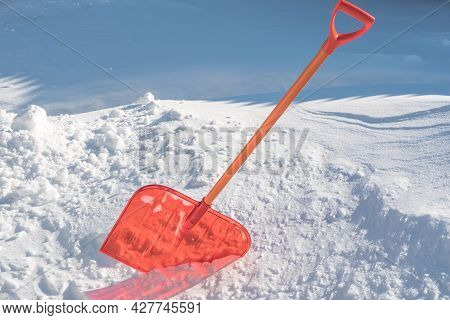 A Snow Shovel Is Stuck In A Snowdrift In Winter In Winter. Snow Removal, Cleaning The Street From Sn