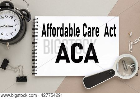 Affordable Care Act Aca, Notepad On A Background Of Different Colors. Brown, Gray. Paper Clips Are B