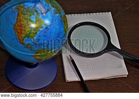 Globe Magnifier Notepad And Pencil On The Table