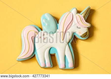Close-up Of Colorful Gingerbread In The Shape Of A Unicorn On A Yellow Background.