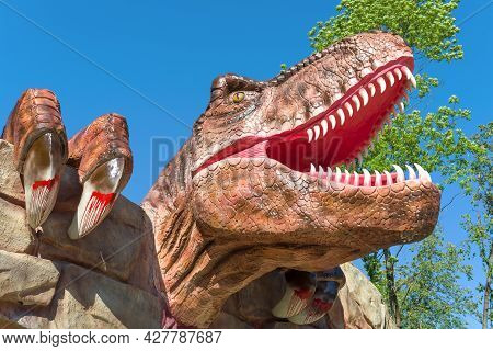 Velikie Luki, Russia - July 04, 2021: Head Of A Carnivorous Dinosaur Over The Entrance To Dinopark C