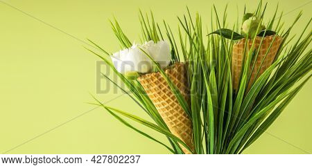 Two Natural Waffle Cones With White Peony Flower On A Green Background. Festive Creative Concept For