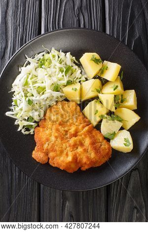 Polish Food Kotlet Schabowy With Boiled Potatoes And Cabbage Salad Close-up In A Plate On A Black Ba