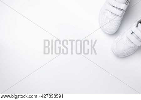 Flat Lay Two White Sneakers Partially Located In The Corner With Free Space For Text Isolated On A W