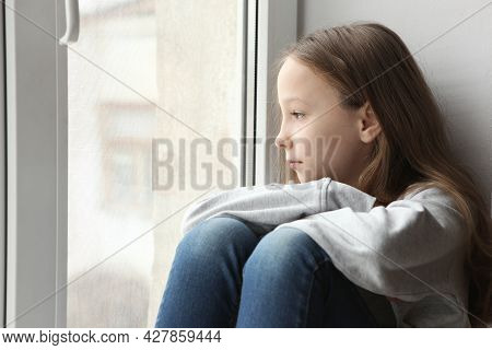 Lonely Sad Girl At Home. Saddened Alarmed Child Alone At Home.