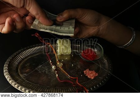 Raksha Bandhan Special Plate Decorated With Rakhi Sweet Kumkum And Brother Gifting Sister
