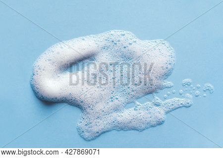 Face Cleansing Mousse Sample. White Cleanser Foam Bubbles On Blue Background. Soap, Shower Gel, Sham