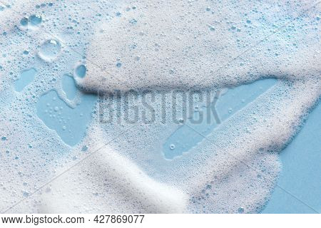 Face Cleansing Mousse Sample. White Cleanser Foam Bubbles On Blue Background. Soap, Shower Gel, Sham