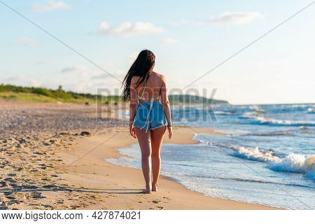 Lonely Young Woman Walking On The Beachsunset Day.beach Woman In Fashion Beachwear Relaxing Walking 