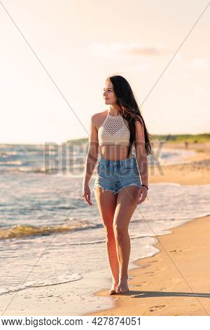 Lonely Young Woman Walking On The Beachsunset Day.beach Woman In Fashion Beachwear Relaxing Walking 