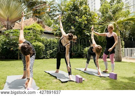 Outdoor Yoga Class Led By Experienced Young Female Instructor, Wellness Concept