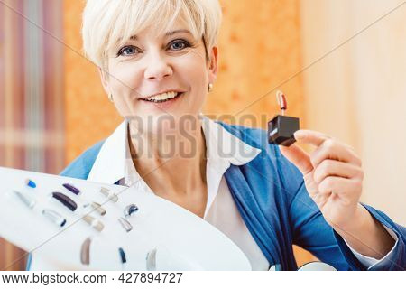Senior woman with impairment choosing hearing aid