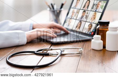 Doctor Woman Using Laptop Having Video Chat With Physicians Indoor