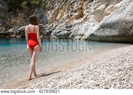 Woman Walking On Beautiful Remote Rocky Beach