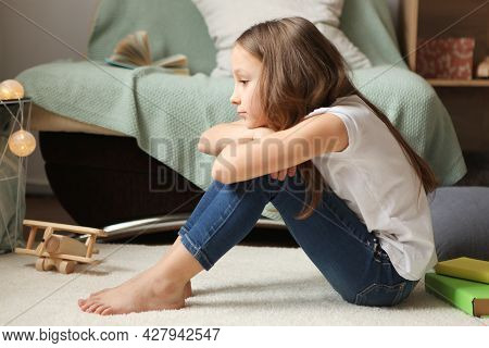 Lonely Sad Girl At Home. Saddened Alarmed Child Alone At Home.