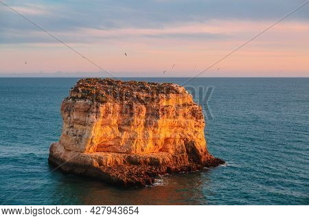 Rock at sunset light on famous beach of Praia dos Caneiros. Algarve.Portugal