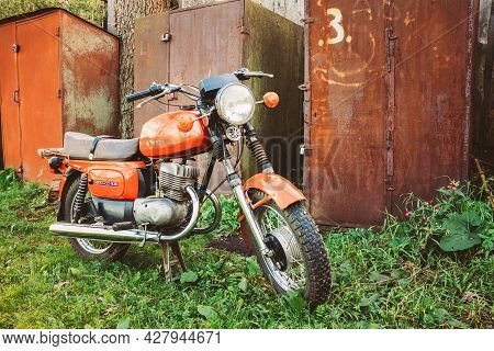 Minsk, Belarus - September 22, 2013: Old Red Russian Soviet Motorcycle Parked On Green Grass Yard. T