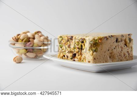 Organic Halva With Pistachios On A White Plate Isolated On White. Traditional Middle Eastern Sweets.